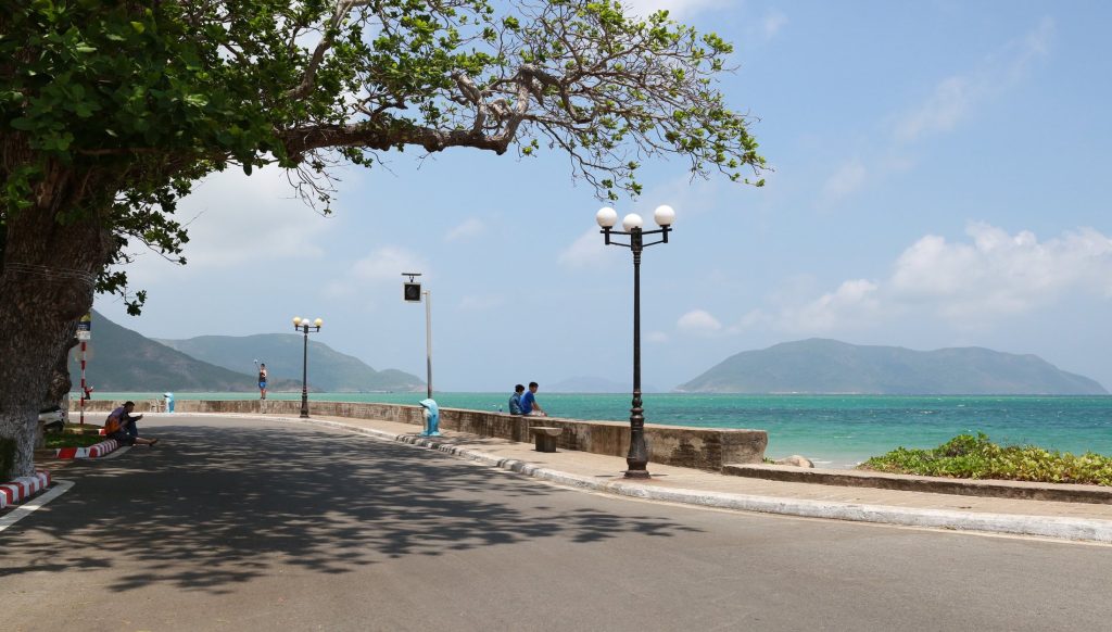 Island road beside turquoise sea and mountain views